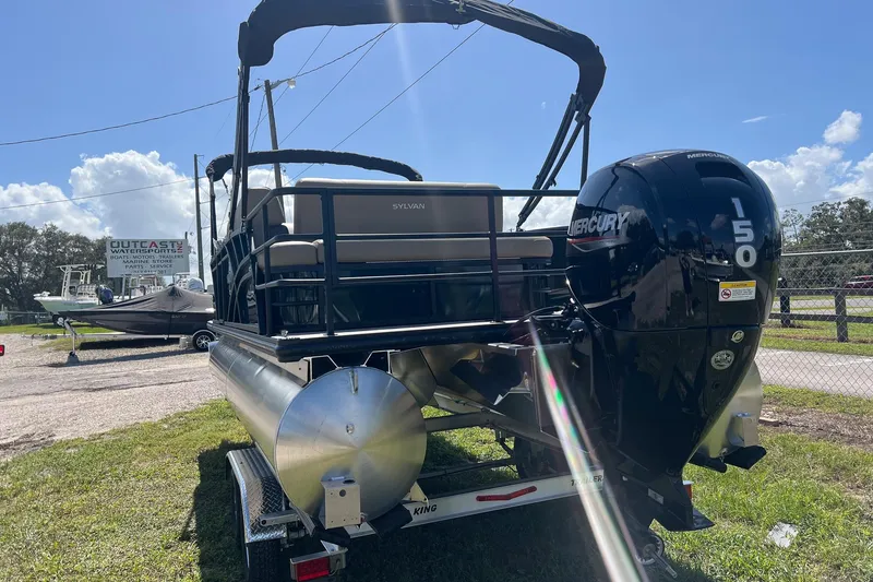 Slide: The Image of 2026 Sylvan Mirage 822 CLZ pontoon boat with Mercury 150 engine, parked outdoors. - 4