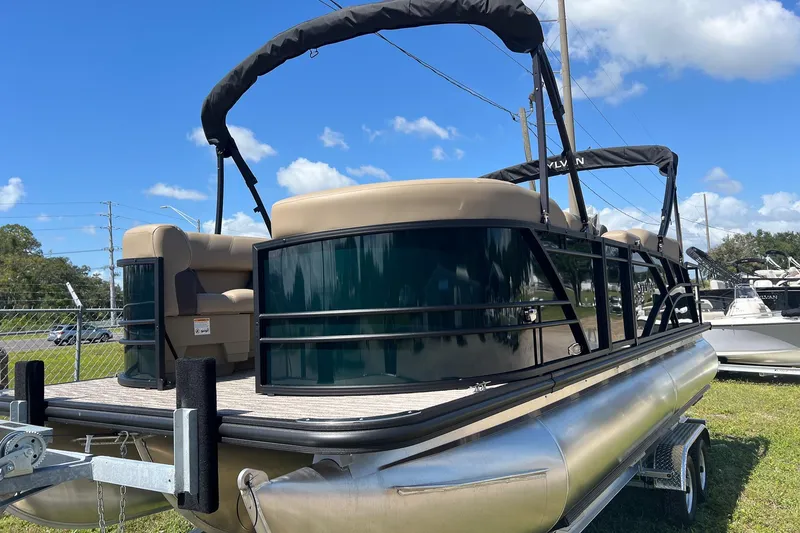 Slide: The Image of 2026 Sylvan Mirage 822 CLZ pontoon boat on trailer under blue sky. - 5