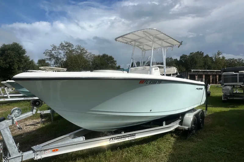 The Image of 2023 Aquasport 2200 Center Console boat on trailer, parked outdoors. - 1