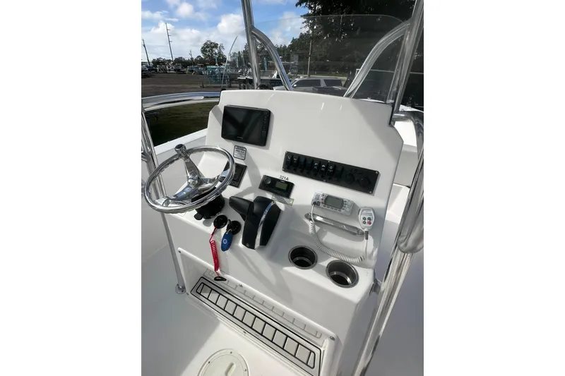 Slide: The Image of 2023 Aquasport 2200 Center Console boat dashboard with steering wheel and controls. - 11