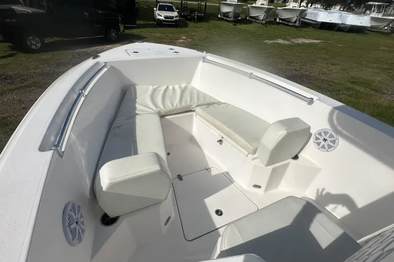Slide: The Image of 2023 Aquasport 2200 Center Console boat interior with cushioned seating and speakers. - 13