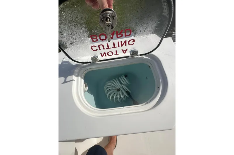 Slide: The Image of Open hatch on 2023 Aquasport 2200 Center Console boat showing storage compartment. - 23