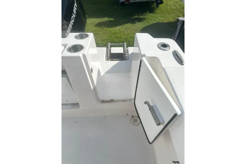 Slide: The Image of 2023 Aquasport 2200 Center Console boat interior with open hatch and cup holders. - 25