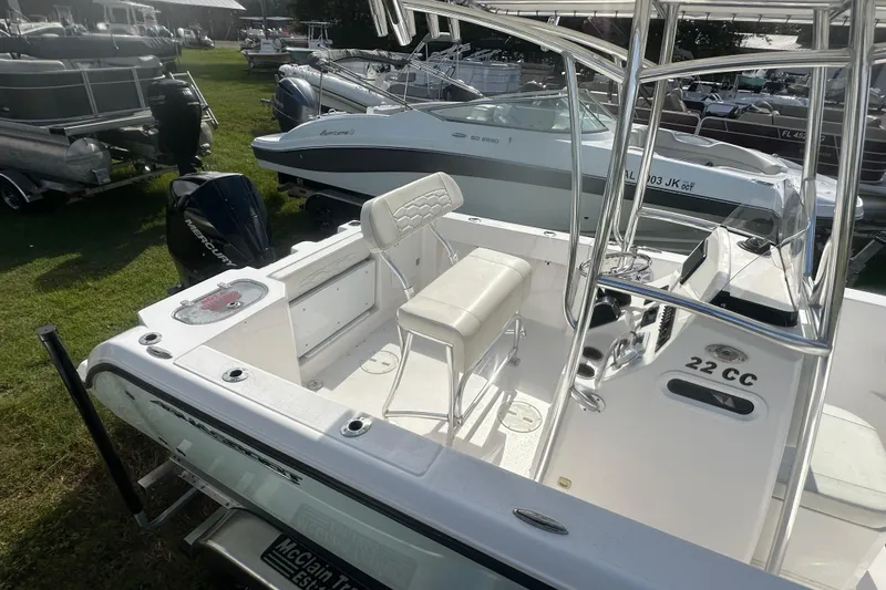 Slide: The Image of 2023 Aquasport 2200 Center Console boat with seating and Mercury engine, displayed outdoors. - 7