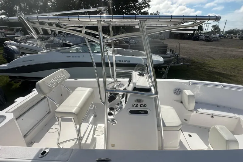 Slide: The Image of 2023 Aquasport 2200 Center Console boat with seating and T-top in a marina setting. - 8