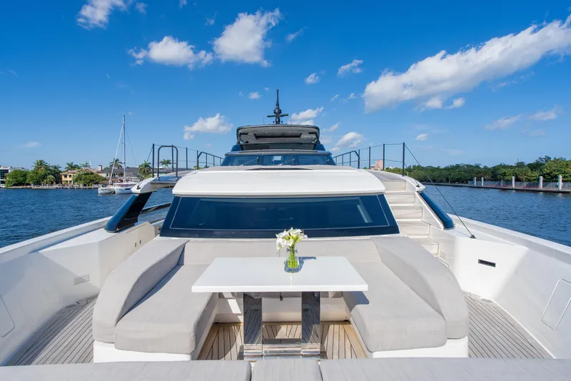 Slide: The Image of 2023 Sanlorenzo SL96A yacht with elegant deck seating and table, under a clear blue sky. - 45