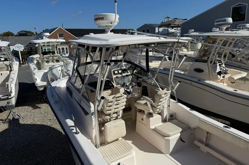 Slide: The Image of 2008 Grady-White Seafarer 228 boat with cockpit view, parked at a marina. - 2