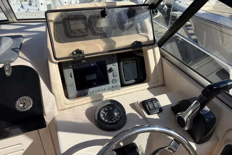 Slide: The Image of 2008 Grady-White Seafarer 228 boat dashboard with navigation instruments and steering wheel. - 5