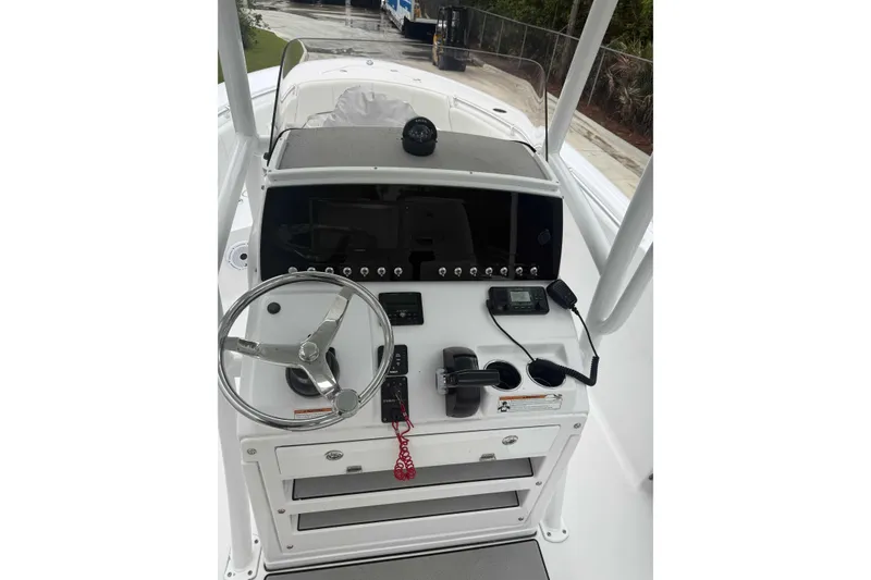 Slide: The Image of 2020 Sportsman Open 232 Center Console boat dashboard with steering wheel and controls. - 2