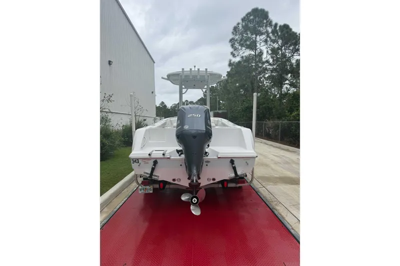 Slide: The Image of 2020 Sportsman Open 232 Center Console boat with outboard motor on red platform. - 20