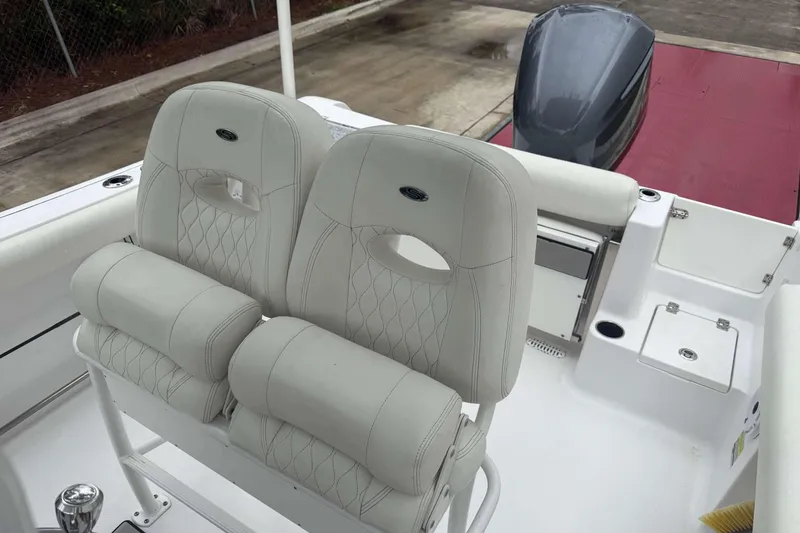 Slide: The Image of 2020 Sportsman Open 232 Center Console boat with dual white cushioned seats and motor. - 4