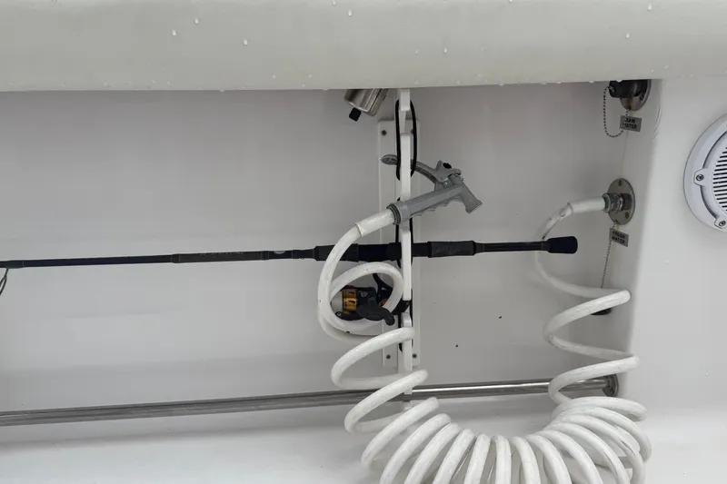 Slide: The Image of 2020 Sportsman Open 232 Center Console boat interior with fishing rod and coiled hose. - 9