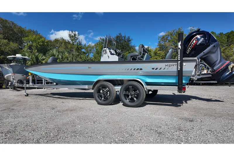 Slide: The Image of 2026 Xpress H24B Bay boat on trailer, parked outdoors under clear sky. - 3