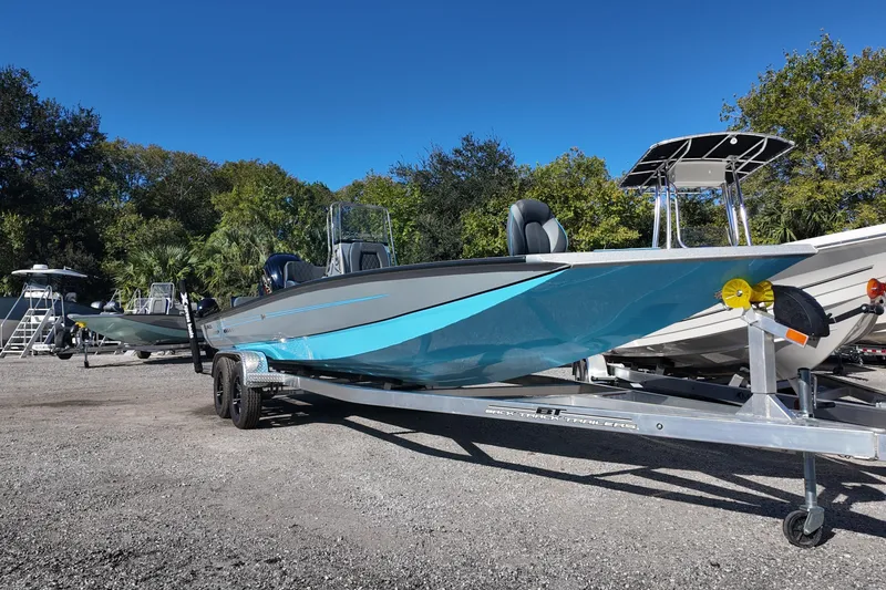 Slide: The Image of 2026 Xpress H24B Bay boat on trailer, parked outdoors under clear blue sky. - 6
