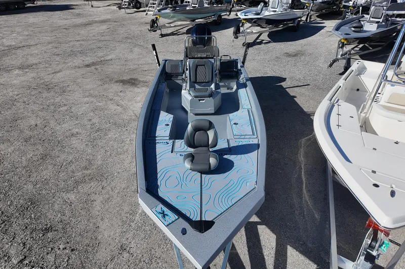 Slide: The Image of 2026 Xpress H24B Bay boat with modern design, parked on gravel lot. - 7