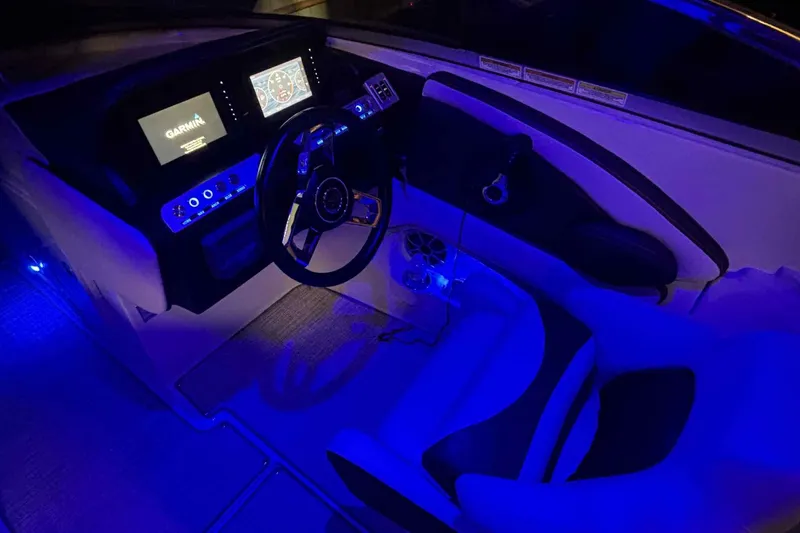 Slide: The Image of 2021 Crownline 290 SS boat cockpit with illuminated dashboard and steering wheel. - 16