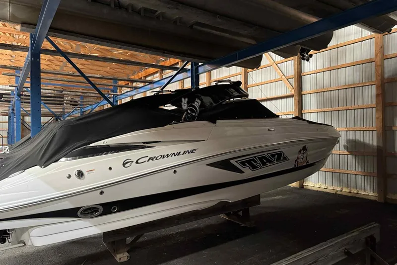Slide: The Image of 2021 Crownline 290 SS boat on trailer under shelter. - 2