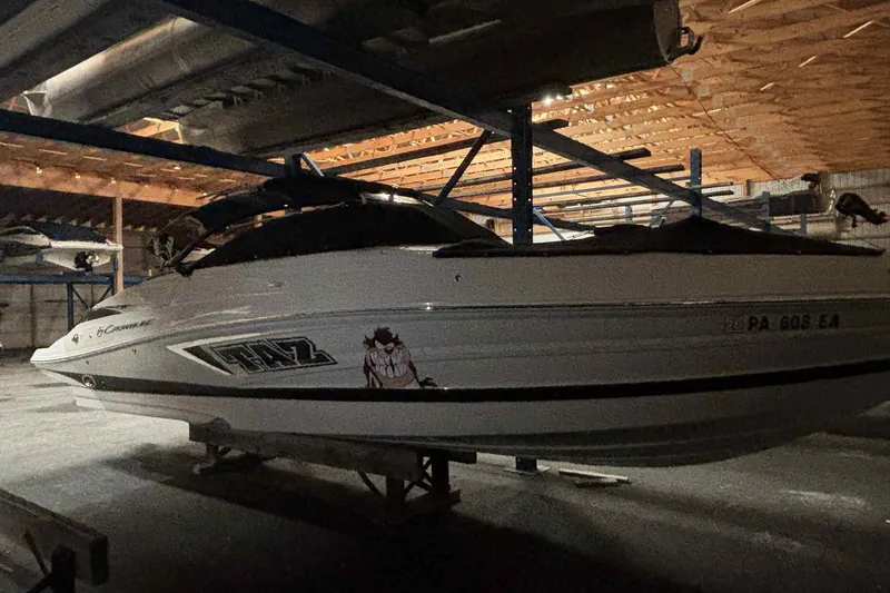 Slide: The Image of 2021 Crownline 290 SS boat cruising on a calm lake with forested shoreline. - 4