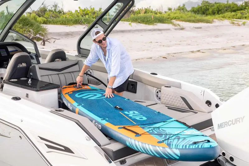 Slide: The Image of 2026 Monterey Elite 30 OB boat displayed in a showroom with twin outboard engines. - 11