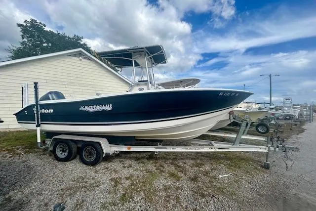 Slide: The Image of 2006 Triton 225 CC boat on trailer, parked outdoors under a cloudy sky. - 0