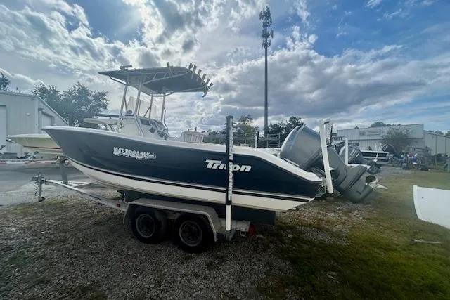 Slide: The Image of 2006 Triton 225 CC boat on trailer under cloudy sky. - 1