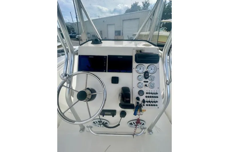 Slide: The Image of 2006 Triton 225 CC boat dashboard with steering wheel and control gauges. - 4