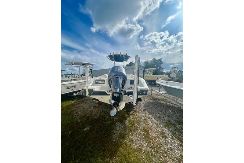 Slide: The Image of 2006 Triton 225 CC boat with outboard motor under a partly cloudy sky. - 6