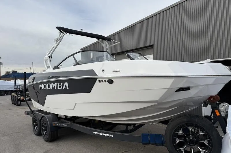 Slide: The Image of 2025 Moomba Max boat on trailer, parked outside a warehouse. - 1