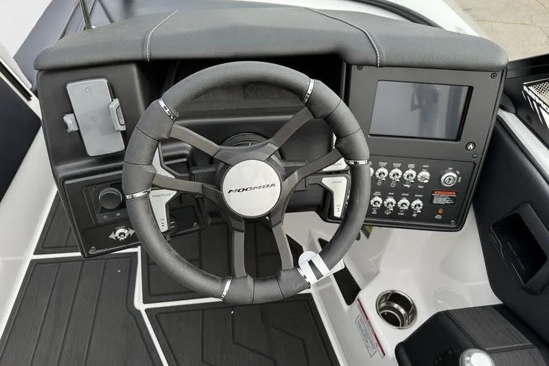 Slide: The Image of Steering wheel and dashboard of 2025 Moomba Max boat, featuring modern controls and display. - 4