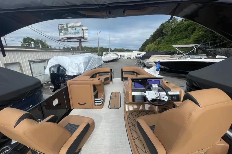 Slide: The Image of 2026 Harris Grand Mariner 250 pontoon boat with luxurious tan seating and modern dashboard. - 10