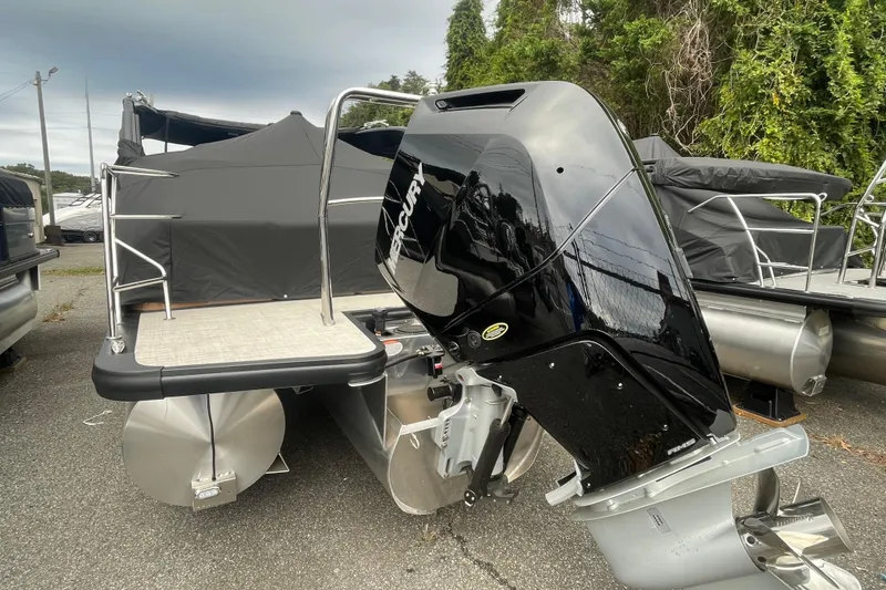 Slide: The Image of 2026 Harris Grand Mariner 250 pontoon boat with Mercury outboard motor, parked outdoors. - 20