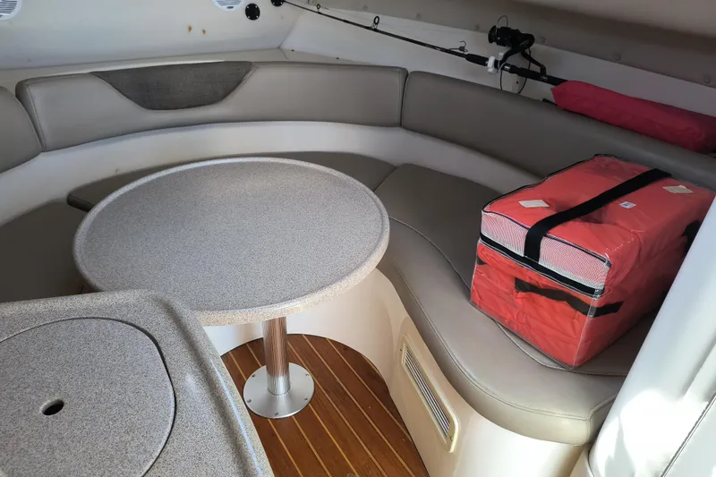 Slide: The Image of Interior of 2002 Boston Whaler 295 Conquest with seating, table, and red cooler. - 12
