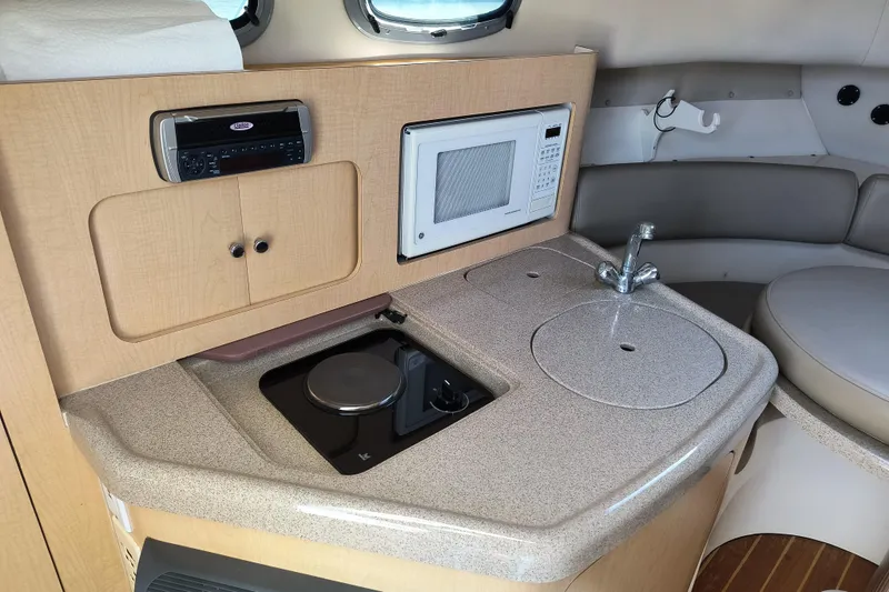 Slide: The Image of 2002 Boston Whaler 295 Conquest cabin kitchen with stove, microwave, and sink. - 14
