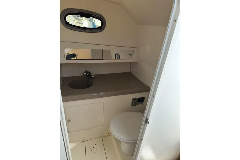 Slide: The Image of 2002 Boston Whaler 295 Conquest boat bathroom with sink, toilet, and mirror. - 17
