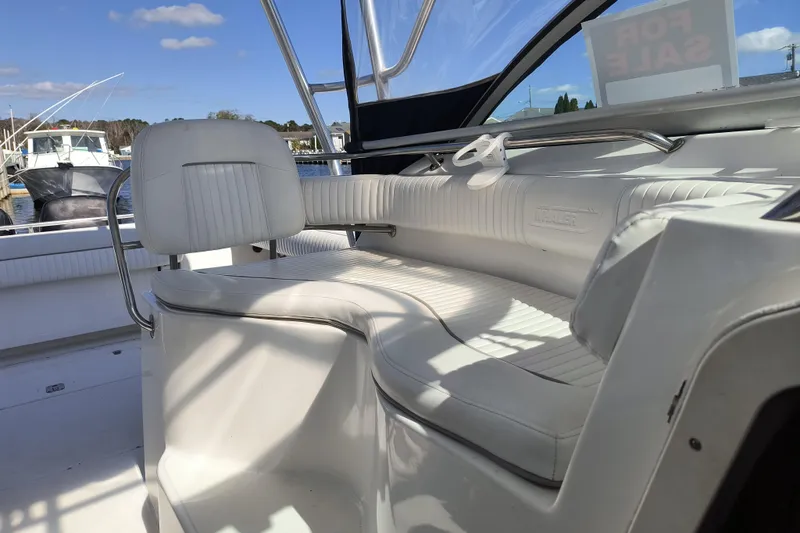 Slide: The Image of 2002 Boston Whaler 295 Conquest boat interior with white seating, for sale sign visible. - 6