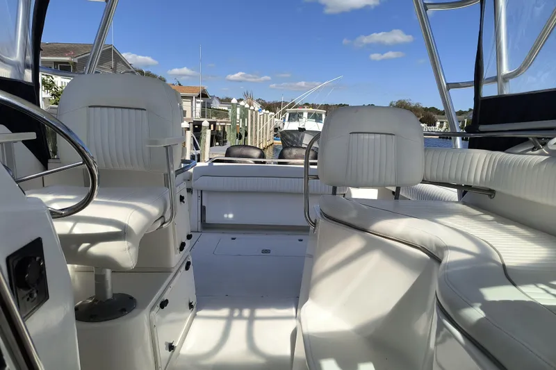 Slide: The Image of 2002 Boston Whaler 295 Conquest boat interior with white seating and clear blue sky. - 9
