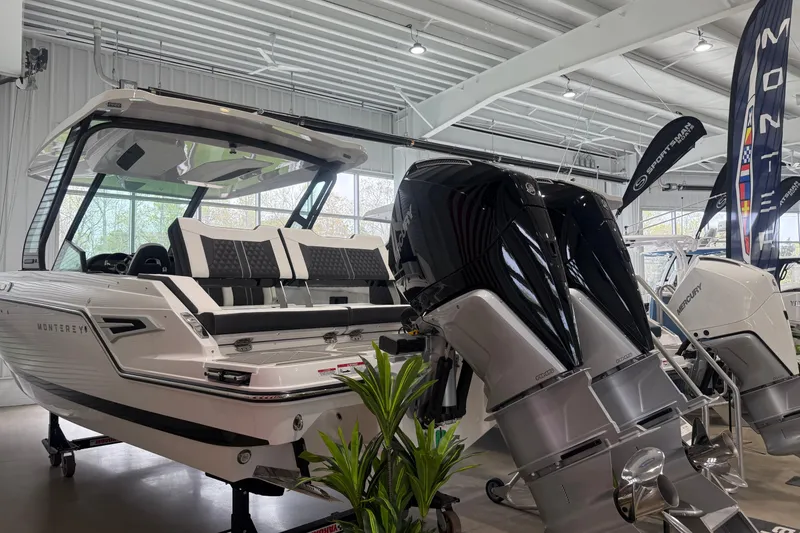 Slide: The Image of 2026 Monterey Elite 30 OB boat with dual outboard engines in a showroom setting. - 2