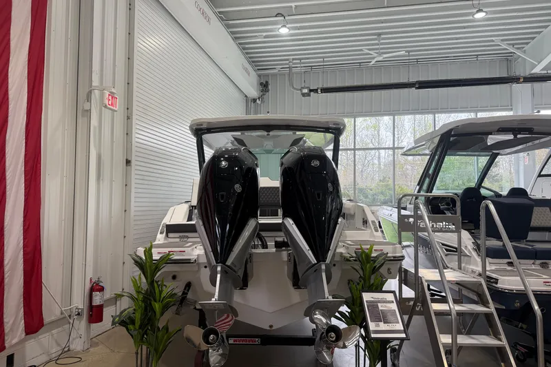 Slide: The Image of 2026 Monterey Elite 30 OB boat with dual outboard motors in a showroom. - 3