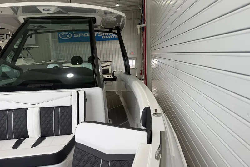 Slide: The Image of 2026 Monterey Elite 30 OB boat interior with sleek seating and modern design in showroom. - 5