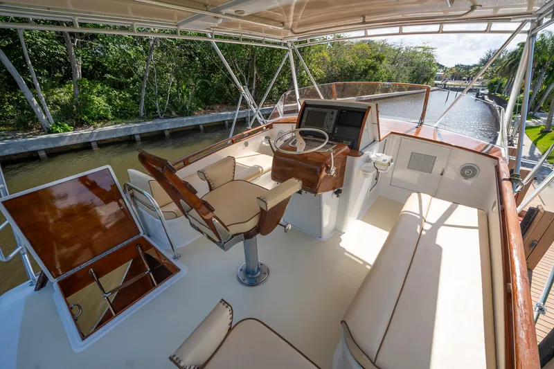 Slide: The Image of 1970 Rybovich 54 yacht helm with seating, wood accents, and canal view. - 11