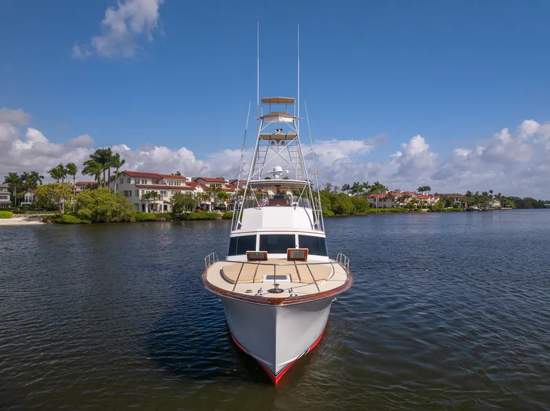 Slide: The Image of 1970 Rybovich 54 yacht on calm water with scenic coastal backdrop. - 2