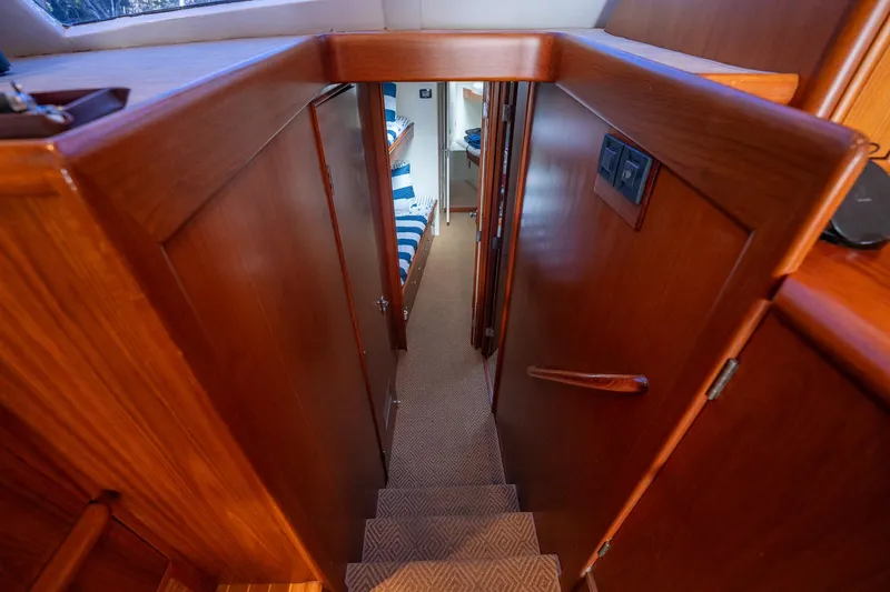 Slide: The Image of Interior view of a 1970 Rybovich 54 yacht, featuring wooden stairs and cabin access. - 27