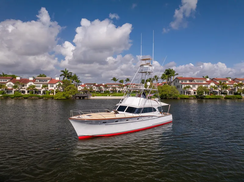 Slide: The Image of 1970 Rybovich 54 yacht on calm water with scenic waterfront homes in the background. - 3