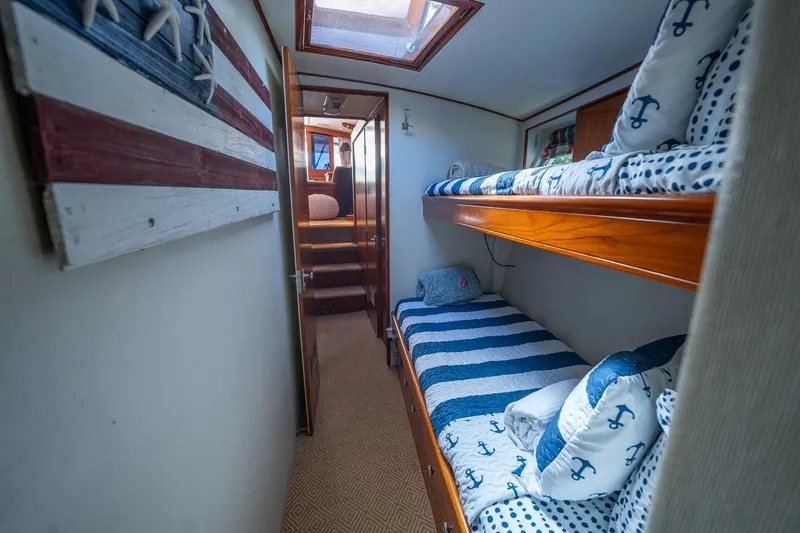 Slide: The Image of Cozy cabin interior of 1970 Rybovich 54 yacht with nautical-themed bunk beds. - 30
