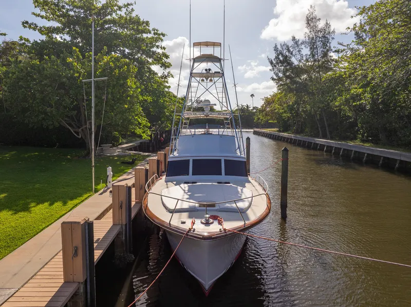 Slide: The Image of 1970 Rybovich 54 yacht docked in a serene canal setting. - 36