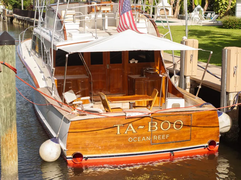 Slide: The Image of 1970 Rybovich 54 yacht docked, featuring wooden deck and "TA-BOO" nameplate. - 39