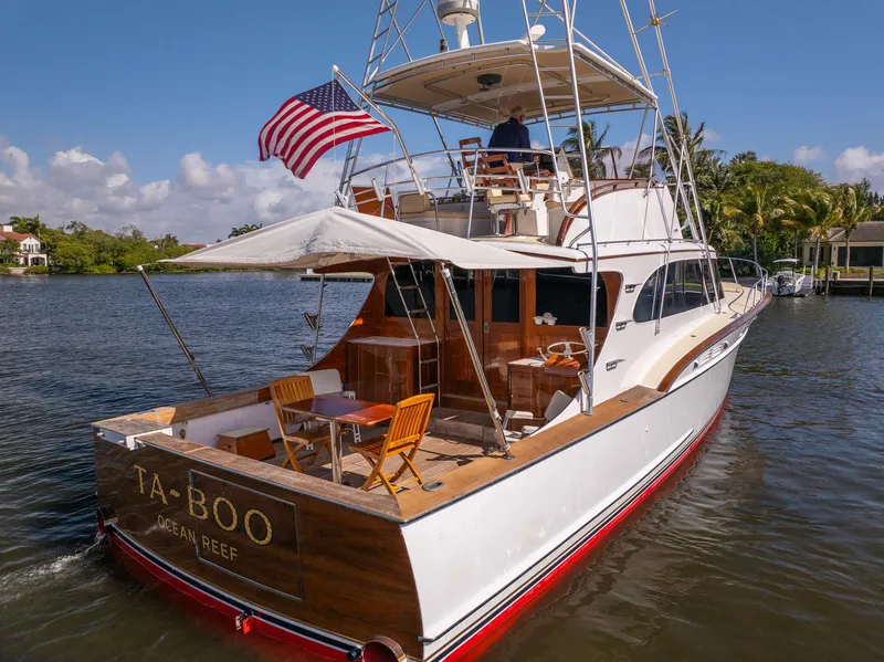 Slide: The Image of 1970 Rybovich 54 yacht with American flag, cruising on a sunny day. - 7