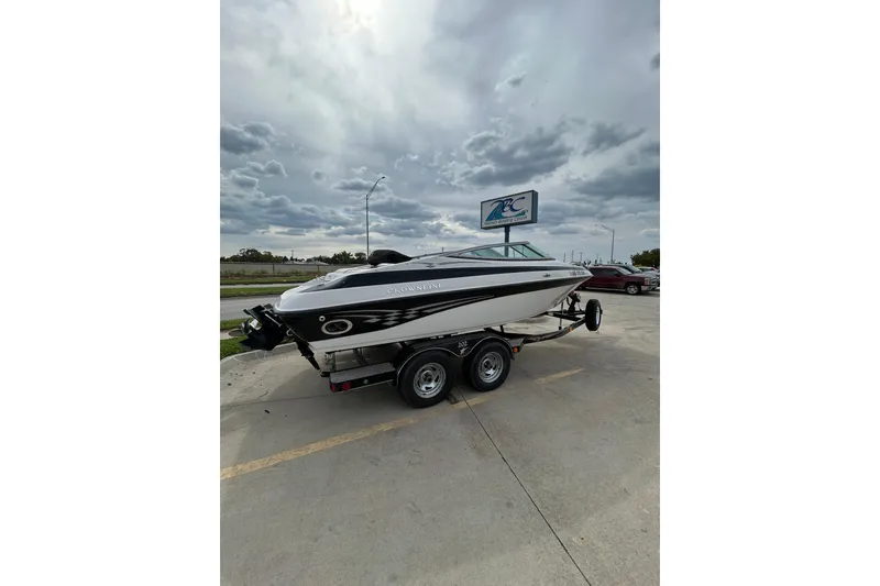 Slide: The Image of 2004 Crownline 202 BR boat on trailer under cloudy sky at dealership. - 10