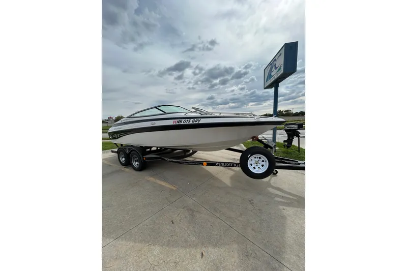 Slide: The Image of 2004 Crownline 202 BR boat on trailer under cloudy sky. - 11