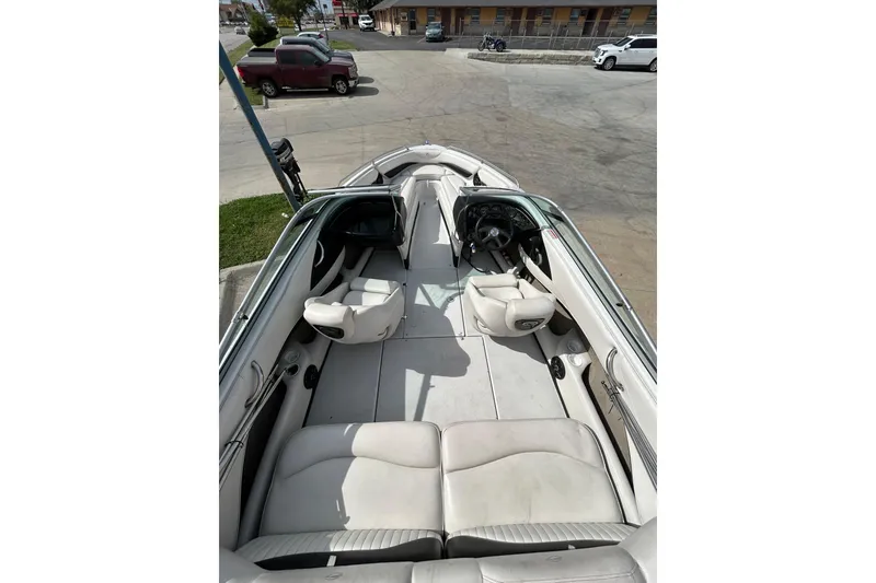 Slide: The Image of 2004 Crownline 202 BR boat interior with white seating and steering wheel. - 16
